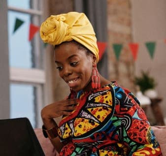 engaged woman with colorful headwrap using laptop